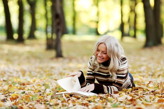 woman read the book in autumn park