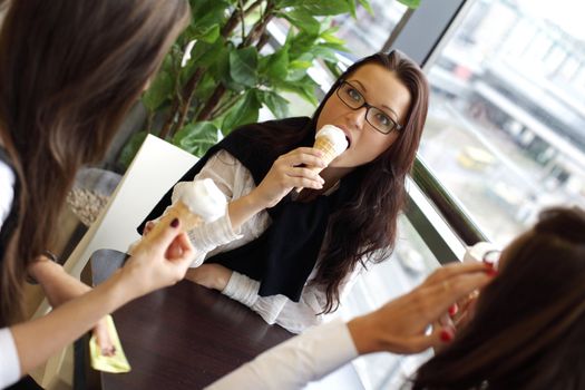 happy smiling women on foreground licking ice cream 