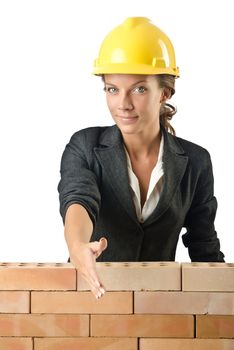 Young female builder near brick wall