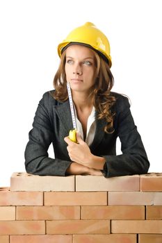 Young female builder near brick wall