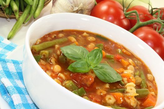 a bowl of minestrone soup and basil