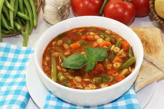 a bowl of minestrone soup and basil