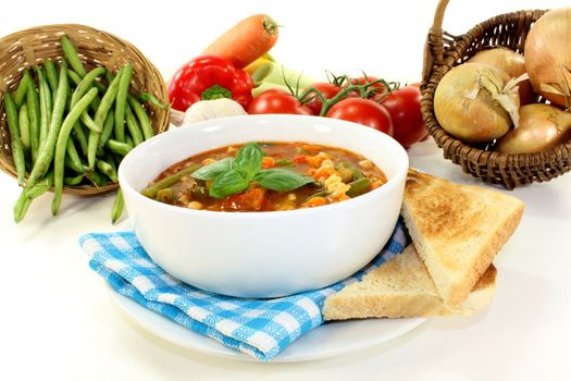 a bowl of minestrone soup and basil