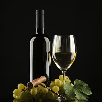 bottle with white wine and glass and grapes