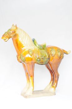 Tri-colored glazed pottery of the Tang Dynasty on a white background