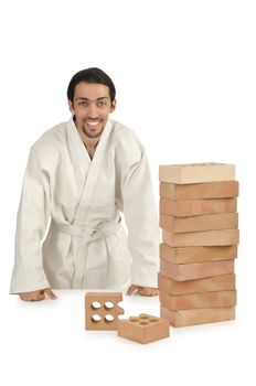 Karate man breaking bricks on white