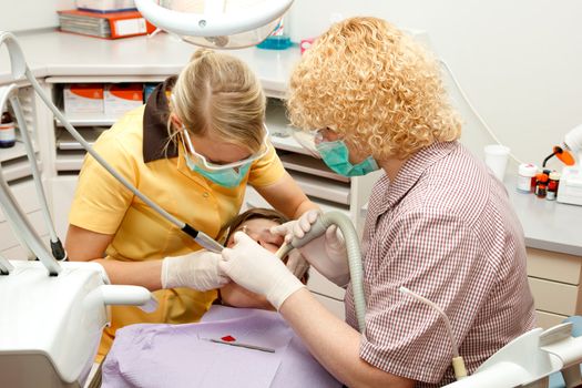 Boy at the dentist. dentist and assistant treating the boy teeth