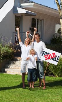 Glowing family after buying a new house standing in the garden