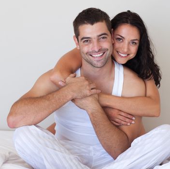 Romantic lovers embracing lying in bed at home 