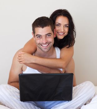 Romantic couple using laptop against white background
