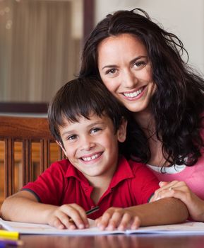 Portrait of happy family drawing at the table