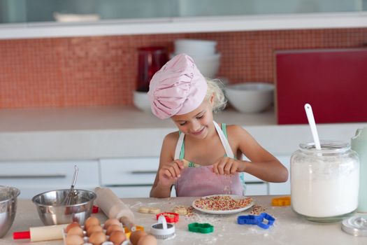Blond girl baking biscuits for her family in the kitchen
