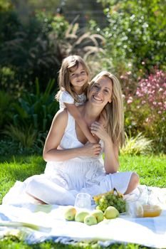 Handsome young mother with her daugther in summer outdoors 