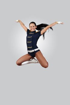 Young female dancer jumping against white background