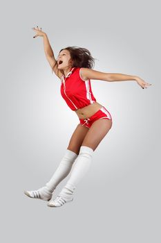 Young female dancer jumping against white background