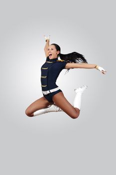 Young female dancer jumping against white background