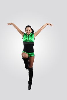 Young female dancer jumping against white background