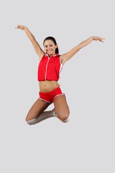 Young female dancer jumping against white background