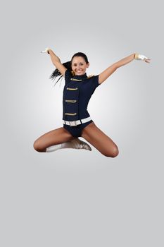 Young female dancer jumping against white background