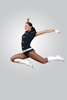 Young female dancer jumping against white background