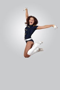 Young female dancer jumping against white background