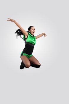 Young female dancer jumping against white background