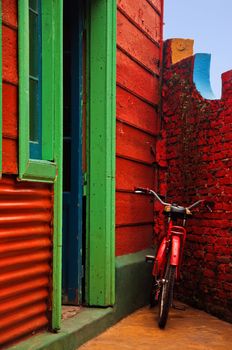 A red bicycle resting against a red wall in Buenos Aires, Argentina.