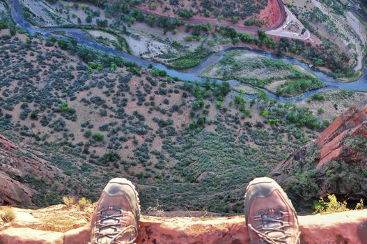 Feet on the edge of rock cliff high above the ground