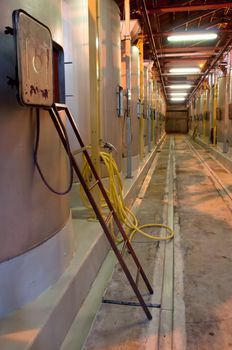 Winery hall with steel wine tanks and ladder, no people