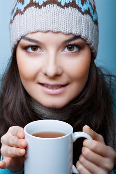 winter woman with СЃup of hot tea on blue background