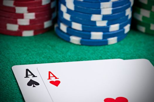 Pair of aces on a poker table with poker chips next to them