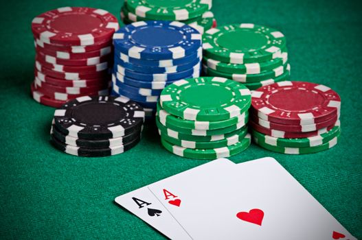 Pair of aces on a poker table with poker chips next to them