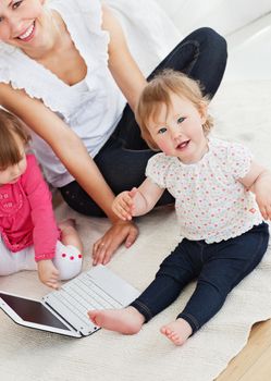 Beautiful family having fun with a laptop in the living-room at home