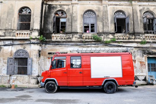 Fire station, red fire truck with space for text and historical building in background