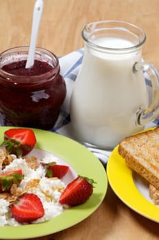 Simple Village Breakfast of Strawberries with Curds and Flakes, Jam, Milk and Toasts closeup on wooden background