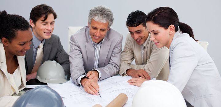 Group of constructors studying plans in a meeting