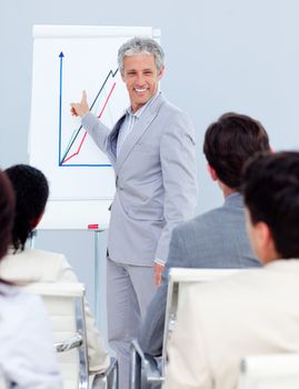 Positive mature businessman doing a presentation to her team