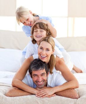 Happy family having fun in the bedroom