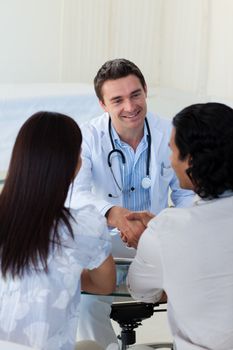 Smiling doctor explaining diagnosis to a couple during a visit