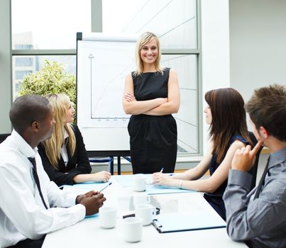 Attractive businesswoman standing in a meeting with folded arms