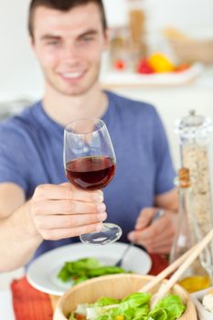 Caucasian man eating a healthy salad with some wine at home