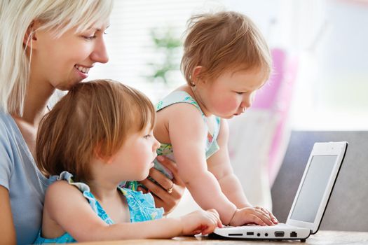 Enthusiastic family having fun with a laptop in the living-room at home 