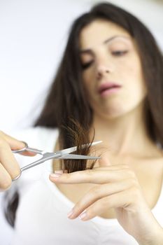 Woman with scissors cutting long ruined hair