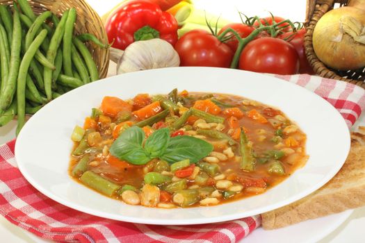 Minestrone with green beans, carrots, potatoes and leeks on a light background