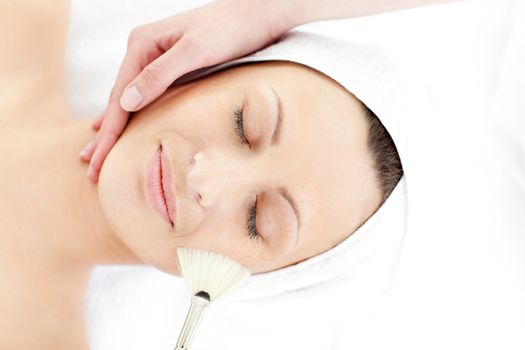 Cute young woman enjoying a beauty treatment in a spa center