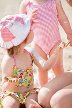 Close-up of a cute little girl at the beach with her family