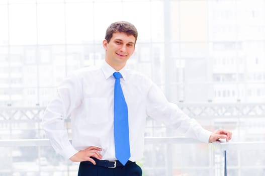 Smiling young business man on the balcony