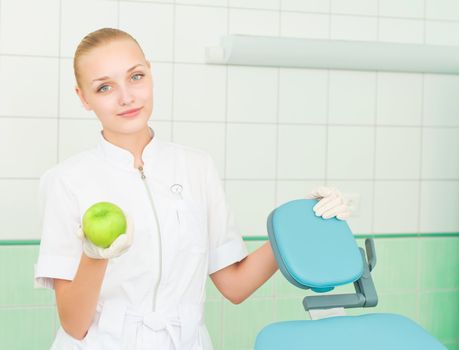 female dentists shows green apple, health care