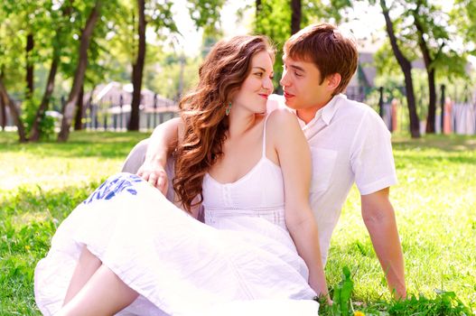 couple in the park sitting on the grass, have a good time together