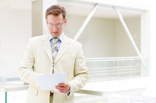 Smiling business man in glasses , holding reports